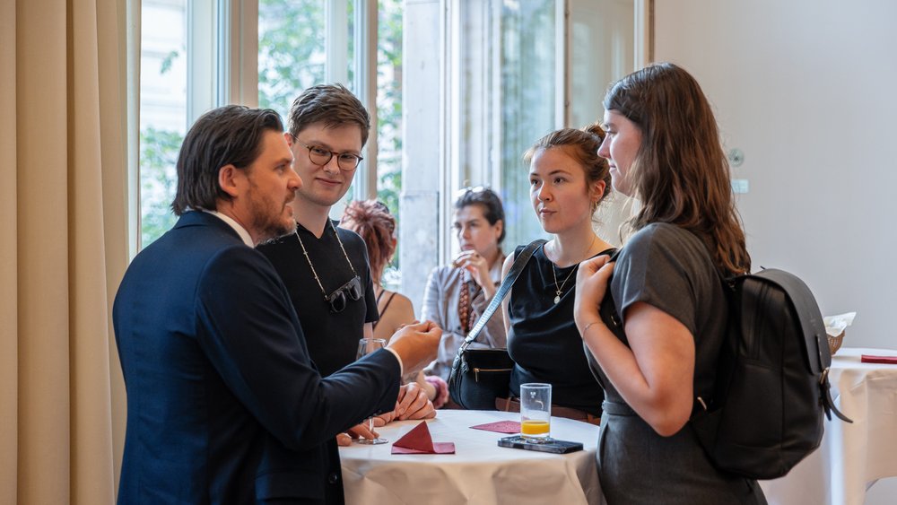 Colour photo: The audience discusses the lecture afterwards