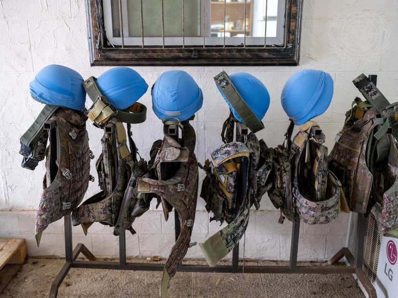 Blue helmets and protective waistcoats are lined up one behind the other