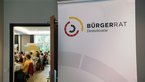 Plakataufsteller beim ersten bundesweiten Bürgerrat mit Plakat mit Aufschrift "Bürgerrat Demokratie "