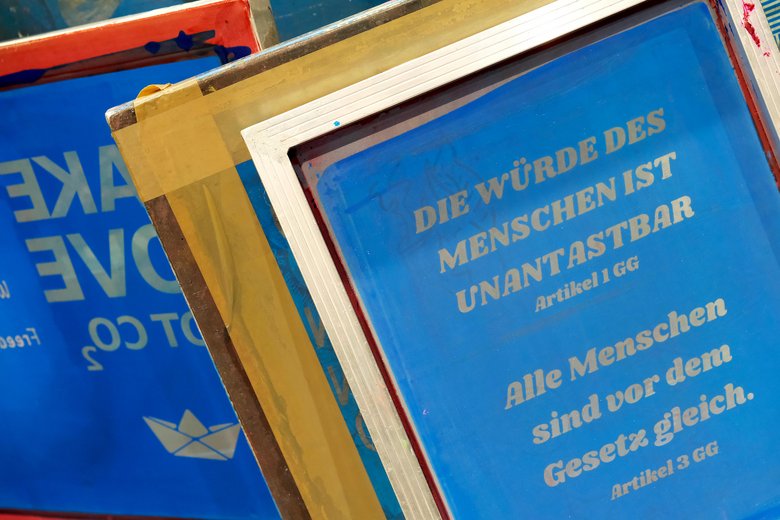 Colour photograph: blue screen print featuring Articles 1 and 3 of the German Constitution.