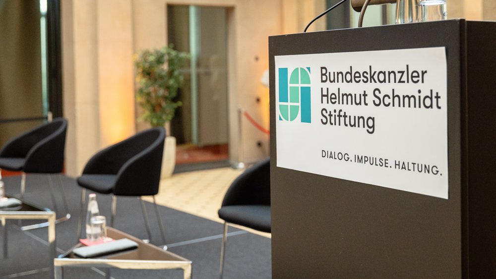 Colour photograph: A podium bearing the foundation’s logo. The slogan reads: Dialog, Impulse, Haltung.