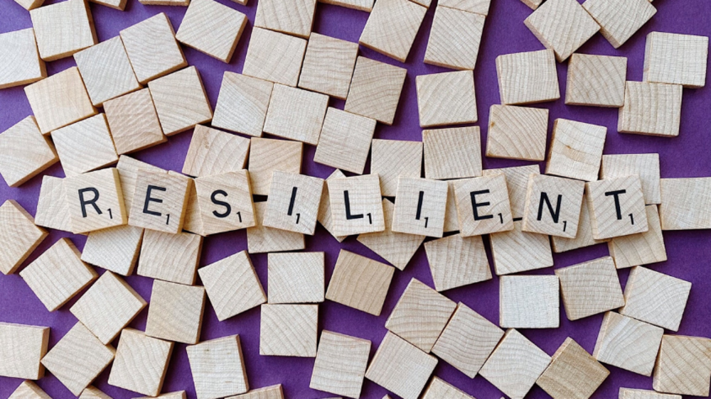 Bauklötze mit Buchstaben aneinandergereiht zum Wort "Resilient"