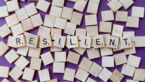 Bauklötze mit Buchstaben aneinandergereiht zum Wort "Resilient"