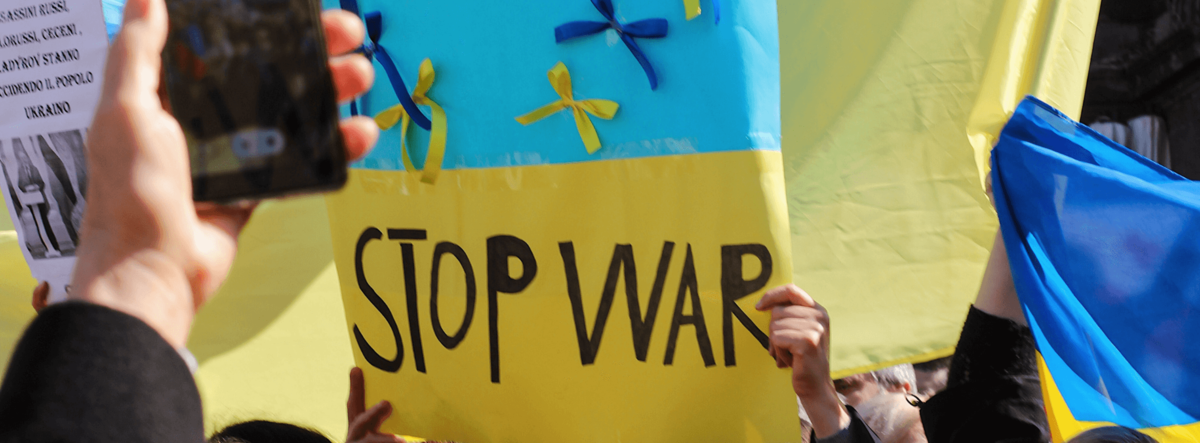 Ein Plakat mit der Aufschrift „Stop war“. Das Plakat enthält die Farben der ukrainischen Flagge.