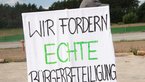 Demonstrationsplakat mit Aufschrift "Wir fordern echte Bürgerbeteiligung"