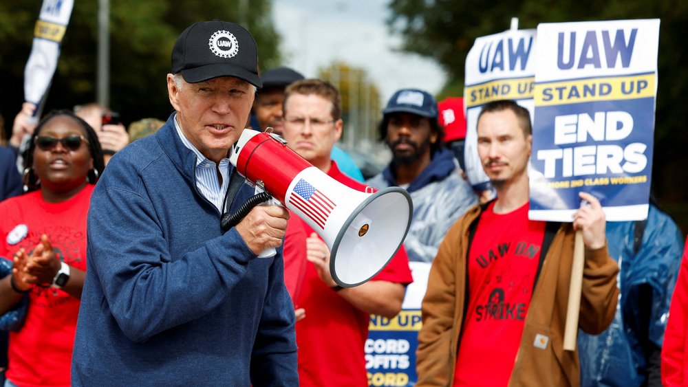 Joe Biden with megaphone together with striking members of the United Auto Workers in Michigan