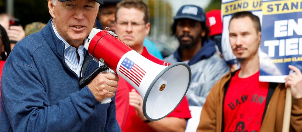 Joe Biden mit Megafon gemeinsam mit streikenden Mitgliedern der United Auto Workers in Michigan