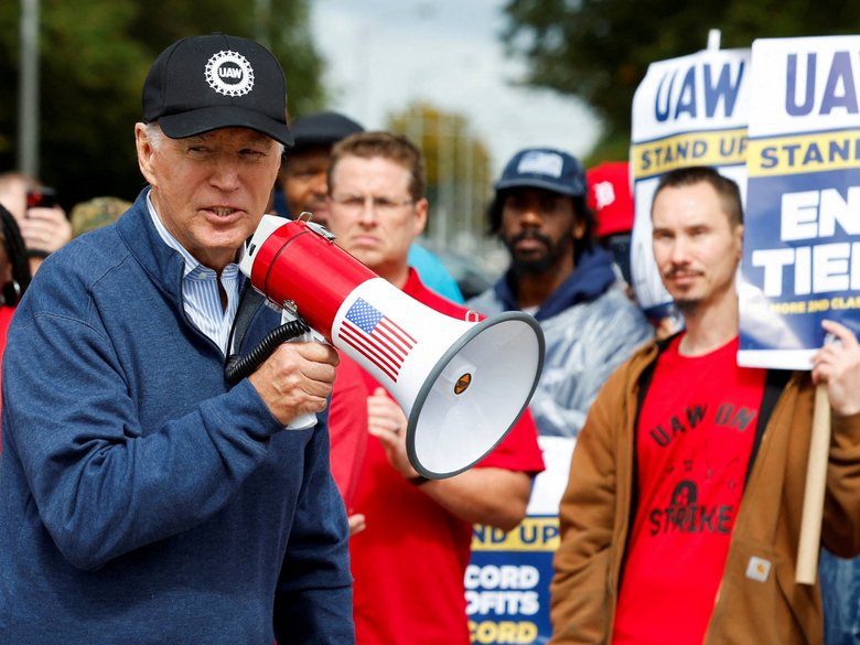 Joe Biden with megaphone together with striking members of the United Auto Workers in Michigan