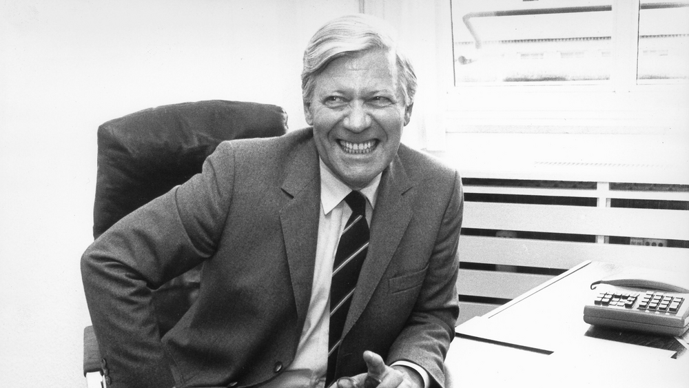 Helmut Schmidt at desk, laughing
