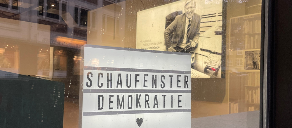 Schild im Schaufenster mit dem Titel "Schaufenster Demokratie"