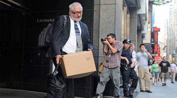 Ein Mann in Anzug verlässt mit einem Pappkarton ein Gebäude der Investmentbank „Lehman Brothers“ am New Yorker Times Square. 