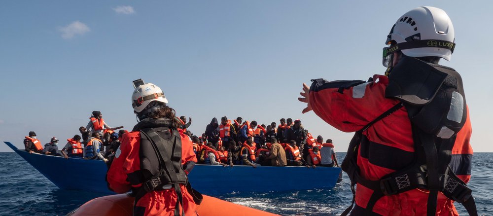 Rescue team and refugee boat