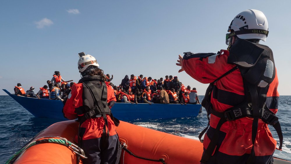 Rescue team and refugee boat