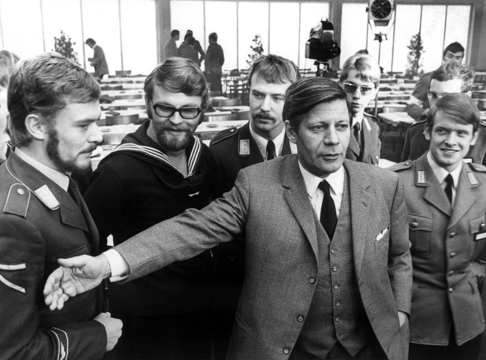 Black and white photograph of Helmut Schmidt in front of soldiers of the air force, navy and army
