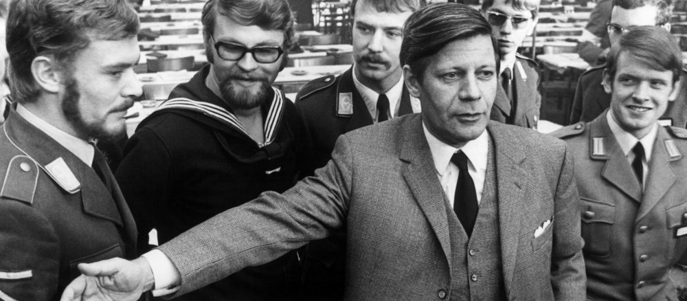 Schwarz-Weiß-Aufnahme von Helmut Schmidt vor Soldaten der Luftwaffe, Marine und des Heeres