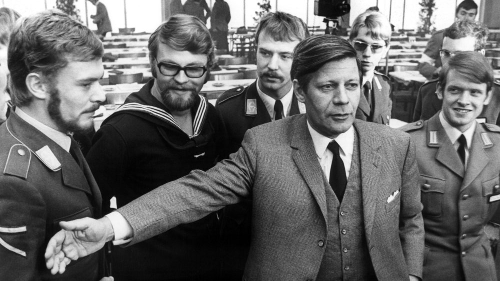 Black and white photograph of Helmut Schmidt in front of soldiers of the air force, navy and army
