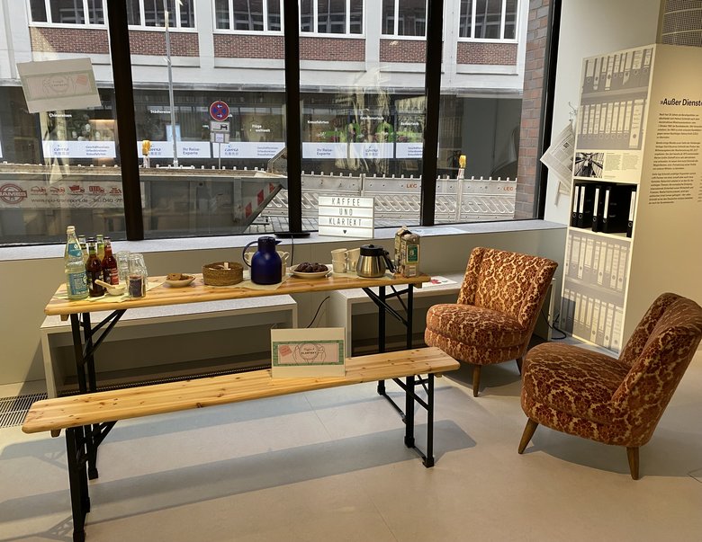 Beer benches with a coffee tray and cosy armchairs next to them.