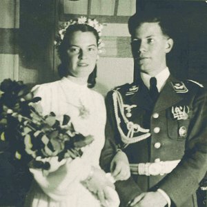 Historical black-and-white photograph: Helmut Schmidt and Hannelore ‘Loki’ Schmidt on their wedding day. She is wearing a white dress and holding a bridal bouquet; he is in uniform.