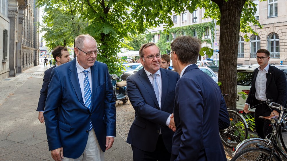 Colour photograph: Peer Steinbrück (left) and Meik Woyke (right) welcome Boris Pistorius (centre)
