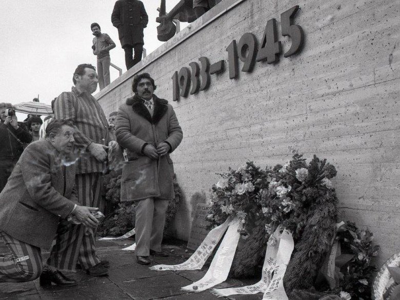 Activists and survivors of the Nazi genocide in front of the memorial wall at the Dachau Concentration Camp Memorial Site