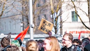 Bild von einder Demonstartion. Eine Flagge und ein Schild werden hochgehalten