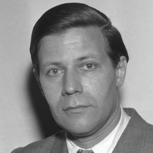 Black-and-white portrait, 1953: Helmut Schmidt in a suit and tie, looking directly at the camera, against a light-coloured background.