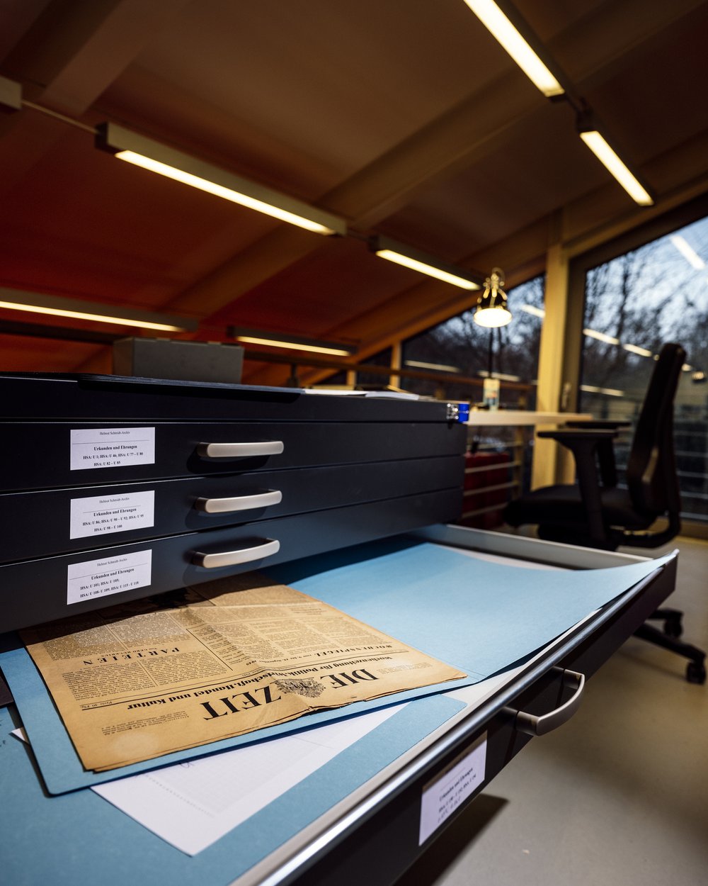 Zeitung liegt in einer geöffneten Schublade eines Archivschrankes