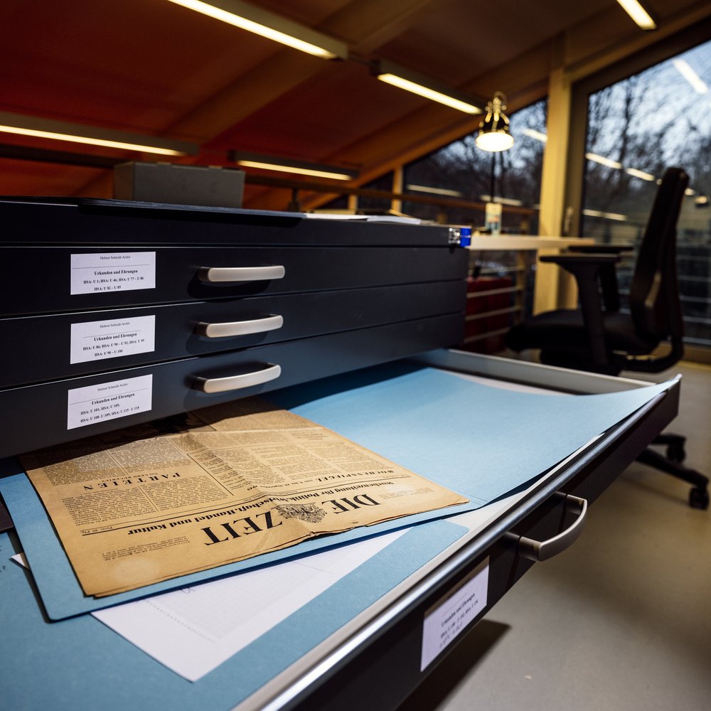 Zeitung liegt in einer geöffneten Schublade eines Archivschrankes