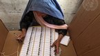 Elderly Afghan woman filling in a ballot paper