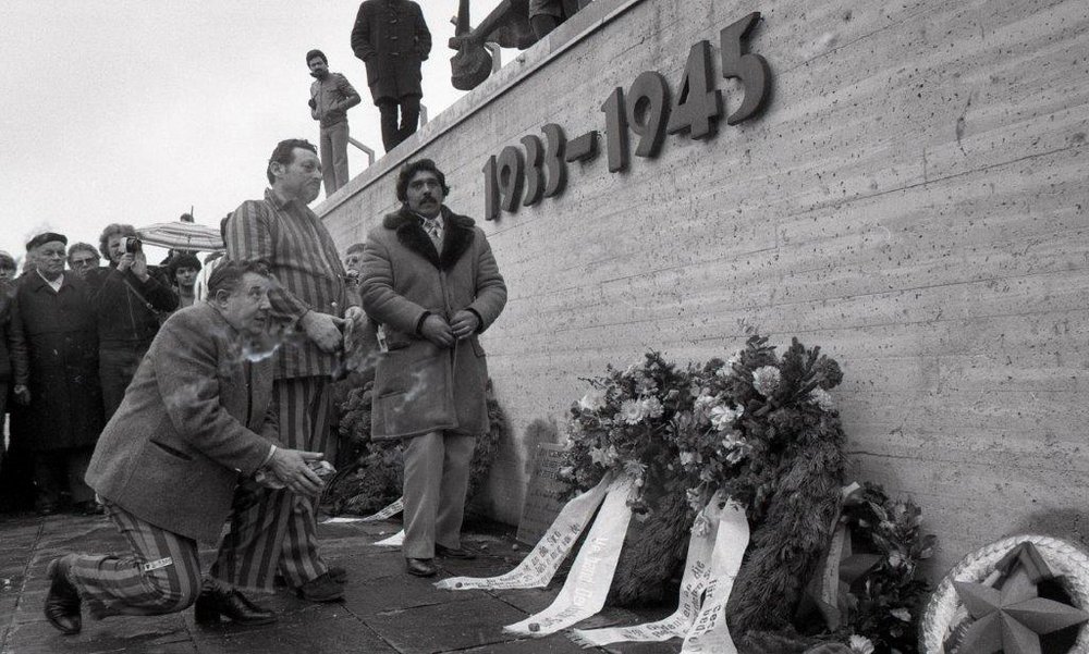 Activists and survivors of the Nazi genocide in front of the memorial wall at the Dachau Concentration Camp Memorial Site
