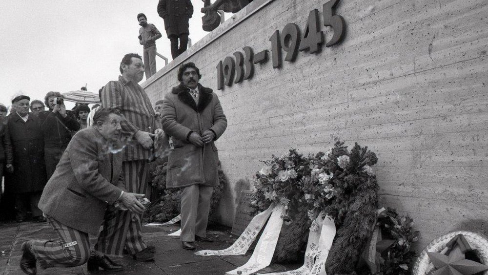 Activists and survivors of the Nazi genocide in front of the memorial wall at the Dachau Concentration Camp Memorial Site